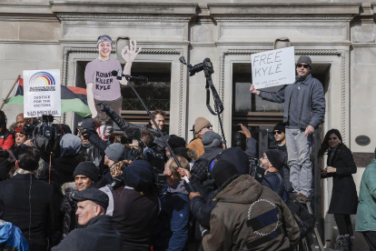 Brandon Lesco (d) sostiene un cartel en oposición fuera del juzgado del condado de Kenosha mientras el jurado declara no culpable de los cinco cargos en el juicio de Kyle Rittenhouse en Kenosha, Wisconsin (EE.UU.).