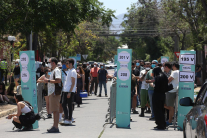 Ciudadanos hacen fila para ingresar a un colegio electoral hoy, en Santiago (Chile).