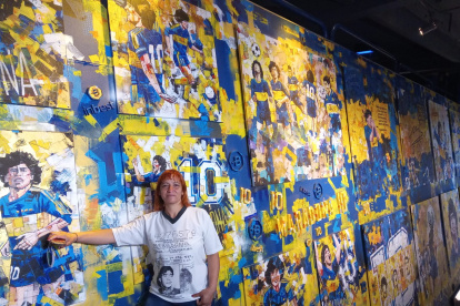 Mariana Vega, integrante de la Iglesia Maradoniana, junto a un mural del astro que pintó Boca Juniors.