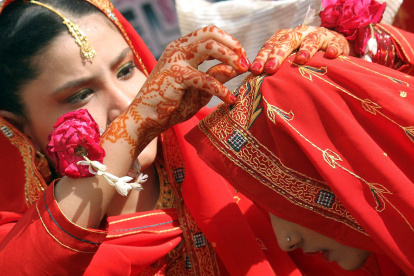 Dos novias se ayudan a colocar el pañuelo durante su ceremonia matrimonial múltiple en Karachi (Pakistán) en una imagen de archivo. EFE/Rehan