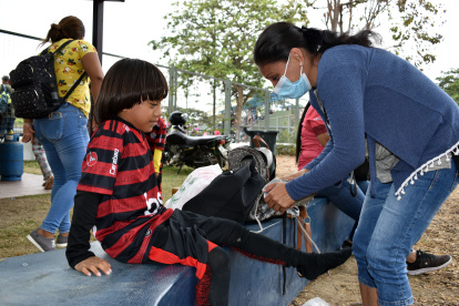 Israel Llerena Rendón, figura de la escuela de fútbol Los Tigrillos y admirador de Lionel Messi, es ayudado con la equipación por su madre Edilma, en la Copa Extra.