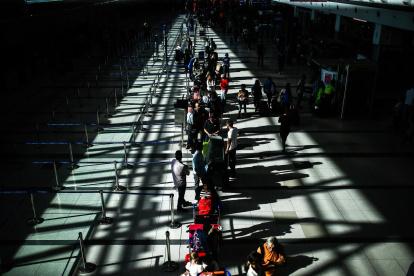 Pasajeros usan tapabocas para protegerse del coronavirus mientras transitan por el Aeropuerto Internacional de Ezeiza, en Buenos Aires (Argentina), en una fotografía de archivo.