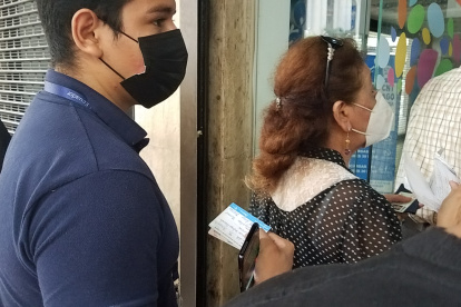 Con su carnet de vacunación a la mano, un ciudadano espera su turno para ingresar a una entidad pública para realizar un trámite.