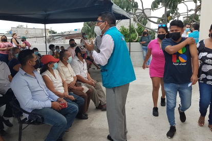 Un funcionario del Ministerio de Salud organiza por número de dosis que van a recibir a los ciudadanos que acudieron a vacunarse en el centro de salud El Cisne, en el suroeste de Guayaquil.