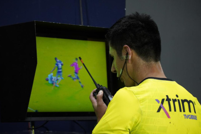 El juez Luis Quiroz se comunica con los árbitros del VAR por una acción dudosa.