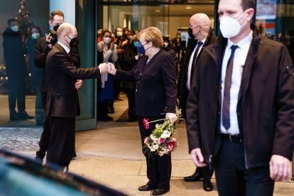 La ex canciller Angela Merkel (3-L) and German Chancellor Olaf Scholz (2-L) greet each other with a fist bump as they part after the official handing over ceremony of the Chancellery in Berlin, Germany, 08 December 2021. A coalition of Social Democratic P