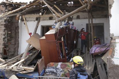 Actuación. Miembros del Cuerpo de Bomberos inspeccionan la casa afectada por efecto de la lluvia.