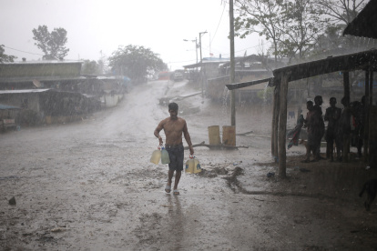 ARCHIVO - Un migrante lleva bajo intensa lluvia un bidón de agua potable a un depósito que sirve de refugio para migrantes en el Tapón del Darién. Foto: Mauricio Valenzuela/dpa ag-periodistas