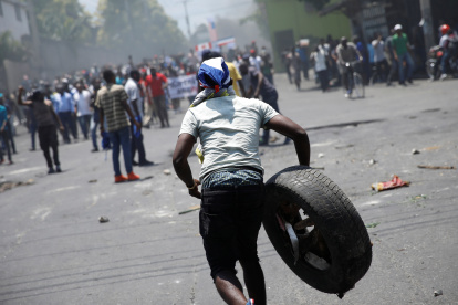 Referencial. Un manifestante porta un neumático durante una manifestación contra el gobierno del presidente Jovenel Moise en las calles de Puerto Príncipe, Haití,