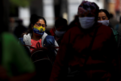 Referencial. Personas con mascarilla caminan por una calle en la ciudad de Quito.