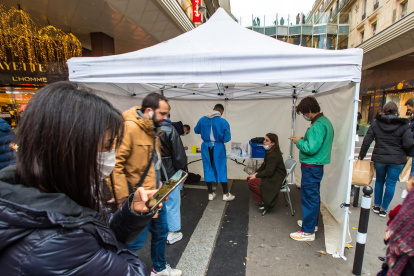 Varias personas esperan para someterse a una PCR en un centro móvil en París.