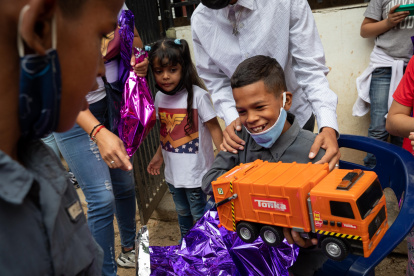 Un niño reacciona luego de abrir un regalo de "Un Juguete, una buena noticia" , en Caracas (Venezuela). EFE/ RAYNER PEÑA R.