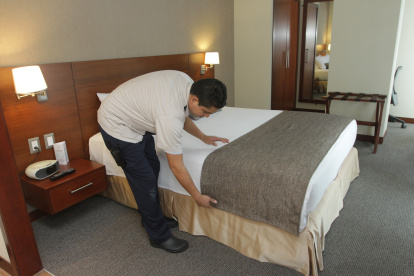 Una persona arregla la cama en un hotel de Guayaquil.