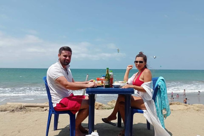 Una pareja degusta un platillo típico de Manta frente al mar. El sector turístico espera dinamismo.