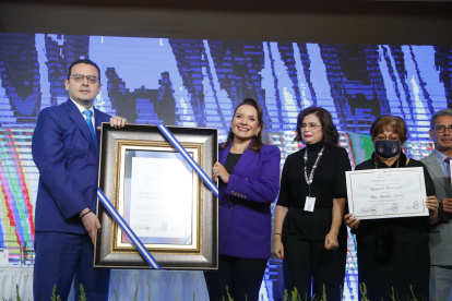 Kelvin Aguirre (i), presidente consejero del Consejo Nacional Electoral, posa junto a la presidenta electa de Honduras, Xiomara Castro (c), durante el acto de entrega de credenciales en el Hotel Plaza Juan Carlos, hoy, en Tegucigalpa (Honduras). Xiomara Castro, del Partido Libertad y Refundación (Libre, izquierda), venció en las elecciones generales del 28 de noviembre a Nasry Asfura, del Partido Nacional, y será quien sucederá en el poder a Juan Orlando Hernández el 27 de enero de 2022. EFE/ Gustavo Amador
