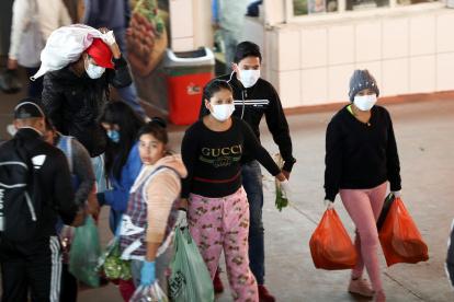 Ciudadanos ecuatorianos se acercan con mascarillas al Mercado de San Roque en el Centro Histórico de Quito (Ecuador), en una fotografía de archivo.