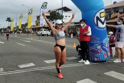 La marchista ecuatoriana Glenda Morejón levanta sus brazos tras cruzar la meta.