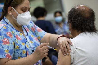 Una persona recibe una dosis de la vacuna contra la covid-19, hoy, en un centro de vacunación de Santiago (Chile)