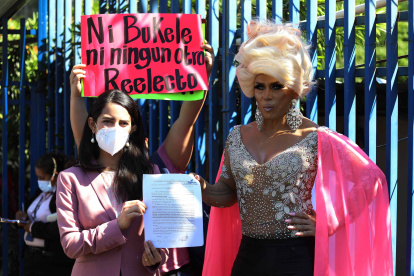 Lady Drag posa junto a la diputada Claudia Ortiz a la salida de la Asamblea Legislativa, hoy, en San Salvador (El Salvador). Lady Drag, un personaje icónico de las protestas contra el Gobierno de Nayib Bukele, presentó este lunes ante la Asamblea Legislativa una propuesta de reforma a dos artículos del Código Penal para que se prohíba la reelección presidencial y se sancione a quienes la promuevan. EFE/ Miguel Lemus