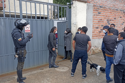 Afectada junto a familiares y curiosos en la puerta de la vivienda donde se robaron el dinero de la caja fuerte.