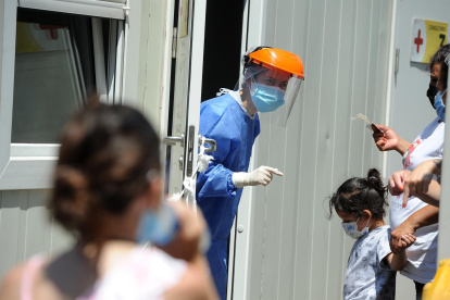 Personal de salud atiende a personas que acuden a realizarse una prueba para detectar la covid-19 en el Hospital Pedro Elizalde, hoy, en Buenos Aires (Argentina). Argentina vive una "tercera ola" de la pandemia marcada por cifras récord de contagios de la variante ómicron, una situación que está colapsando los principales centros de testeo y los sistemas de atención primaria, mientras el Gobierno opta por no imponer restricciones que frustren las vacaciones de verano.
