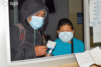Usuarios del transporte interprovincial presentan sus carnés de vacunación en una de las boleterías de la terminal de Cuenca.