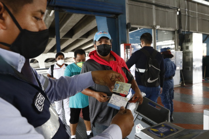 Un funcionario de la Maetrovía revisa el carné de vacunación en la estación de La Atarazana.