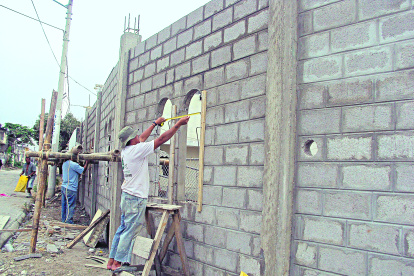 Trabajo.- Albañiles en una construcción de casas.