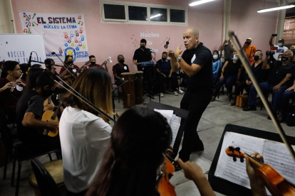 Un maestro de música dirige un concierto de "El Sistema" para invitados extranjeros.