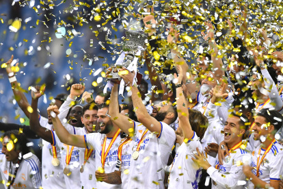 Karim Benzema (c), autor de uno de los dos tantos del equipo, levanta el trofeo de monarcas.