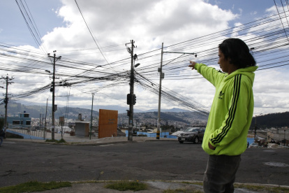 Las Casas. Erick Zumba señala la cantidad de cables que están desordenados en un poste en este sector.