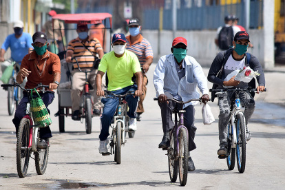 Ciudadanos cubanos recorren las calles de Bayamón, utilizando mascarillas.