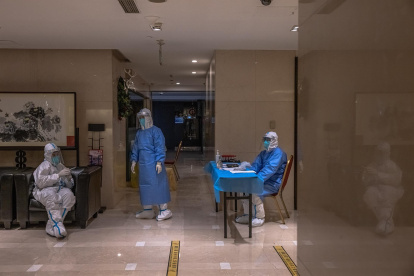 Trabajadores de la salud con equipo protector esperan en un hotel, dentro de la "burbuja" de los Juegos Olímpicos Covid-19, en Pekín, China, la ciudad anfitriona de los Juegos Olímpicos de Invierno de 2022, tras detectar su primer caso transmitido localmente de la variante Omicron COVID-19 .