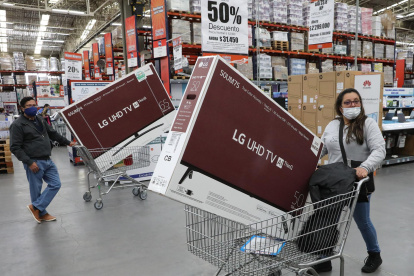 Compradores salen de un almacén llevando electrodomésticos en Bogotá (Colombia), en una fotografía de archivo.