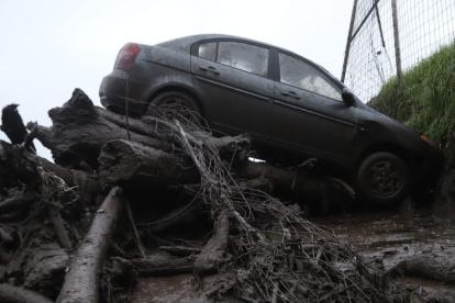 Daños. Decenas de vehículos arrastrados por la corriente terminaron en montículos de troncos y árboles en el sector de La Comuna.