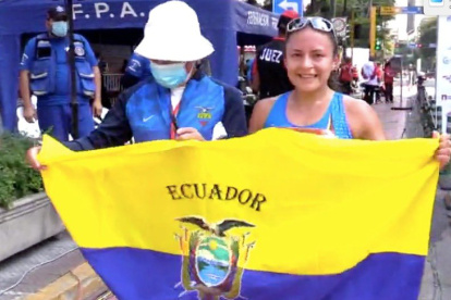 La ecuatoriana Glenda Morejón muestra la bandera tricolor tras lograr el primer lugar en los 20 kilómetros.