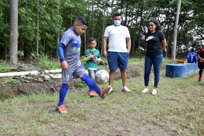 Johnny mientras domina el esférico en uno de los calentamientos. Lo miran orgulloso su padre, Johnny Morales, y su mamá, Leonela.