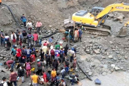 Cientos de personas y maquinaria pesada extraen oro durante el día.
