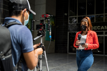 Fotografía fechada el 4 de febrero del 2022 donde se observa a una periodista de un portal privado de noticias en internet mientras hace un reporte, en Caracas