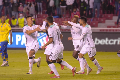 Los jugadores de Liga de Quito corren junto a Jefferson Arce (semioculto) para felicitarlo, luego de marcar el tanto de la victoria para el conjunto albo.