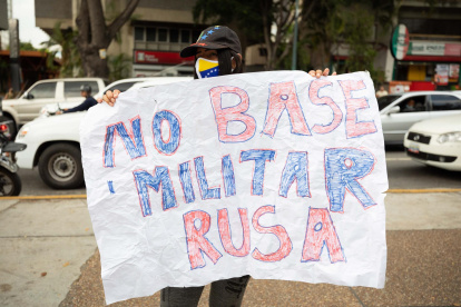 Una mujer fue registrada este viernes con una pancarta que dice "no base militar rusa", durante una manifestación de un grupo de personas que rechaza la incursión militar de Rusia en territorio ucraniano, en Caracas (Venezuela).
