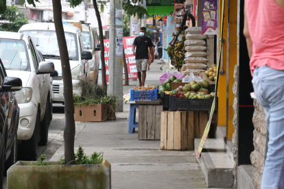 Las veredas de Sauces 6, a lo largo de la avenida Roldós Garcés, están ocupadas por frutas, legumbres y carteles publicitarios. A las personas les resulta imposible transitar por la zona.