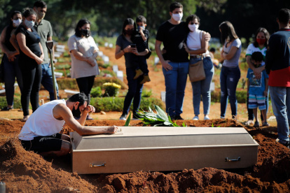 Fotografía de archivo en al que se registró a una familia durante el entierro de un familiar víctima de la covid-19, en el cementerio Vila Formosa, en Sao Paulo (Brasil).