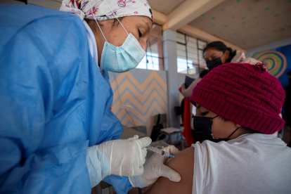 Fotografía de archivo en la que se registró a un niño al ser vacunado contra la covid-19, en un colegio de Quito