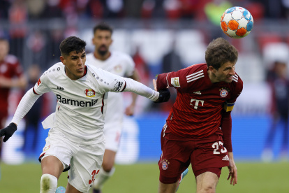 El ecuatoriano Piero Hincapié (izquierda) disputa el balón con el delantero del Bayer de Múnich, Thomas Müller.