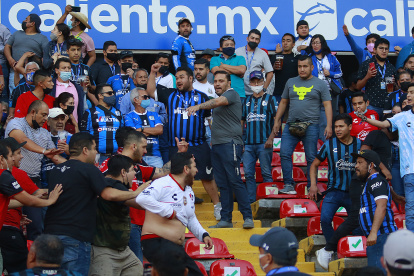 Aficionados de Querétaro y Atlas se enfrentan durante un juego correspondiente a la jornada 9 del Torneo Clausura 2022 de la Liga MX