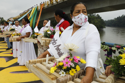 ACOMPAÑA CRÓNICA: COLOMBIA CONFLICTO - PUT400 EL TIGRE (COLOMBIA), 04/03/2022.- Fotografía fechada el 24 de febrero de 2022 que muestra a un grupo de mujeres que sostiene balsas con flores y nombres de víctimas de la violencia en El Tigre, departamento del Putumayo (Colombia). En el puente por el que hace 23 años desaparecieron sus maridos, hijos y hermanos a manos de paramilitares, las mujeres de El Tigre, en el sur de Colombia, no olvidan el pasado para asegurarse de que no se repita la tragedia que partió su historia en dos. El sábado 9 de enero de 1999, a las 23.00 horas, paramilitares de las Autodefensas Unidas de Colombia (AUC) incursionaron en El Tigre, caserío del departamento de Putumayo, quitaron la luz del pueblo y empezaron a quemar casas, carros y motos, cuenta a Efe la presidenta de la Asociación Violetas de Paz, Ruby Tejada Suárez. EFE/ Carlos Ortega