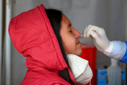 Fotografía de archivo de una mujer mientras se realiza una prueba PCR para detectar covid-19 en Quito (Ecuador).