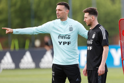 El jugador Lionel Messi (d) escucha instrucciones del entrenador Lionel Scaloni, en una fotografía de archivo.