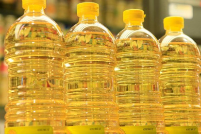 Tienda.- Botellas con aceite en la percha de una tienda.